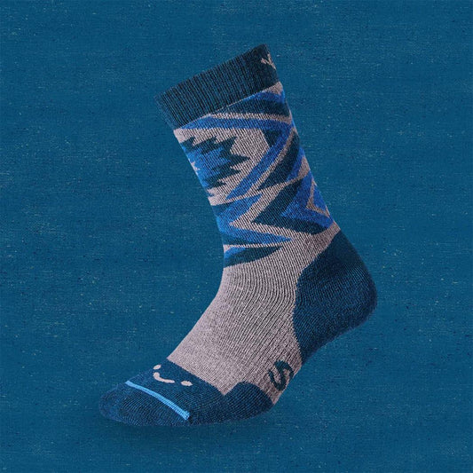Side view of the FITS Retro Pullover Full Cushion Crew Sock in Titanium showing the geometric pattern and crew length against a blue background.