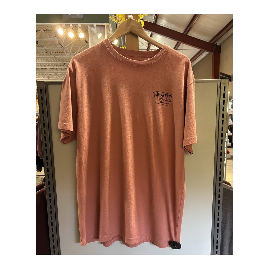 Front view of the Jetty Men's Dive Bar Tee in Mauve hanging on a wooden hanger against a store display.