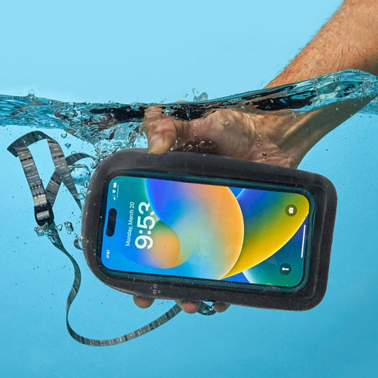 A hand holds the Nite Ize RunOff Waterproof Phone Case Plus in black underwater, showing the phone screen and attached strap against a blue background.