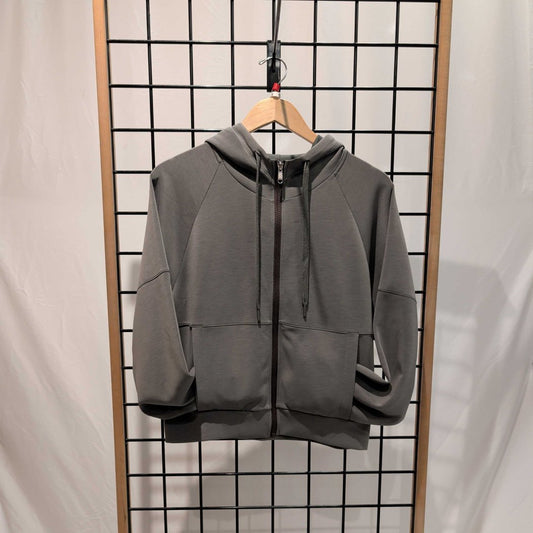 Front view of the Prana Womens Shae Full Zip-SAMPLE in Thyme hanging on a wooden hanger against a grid background.