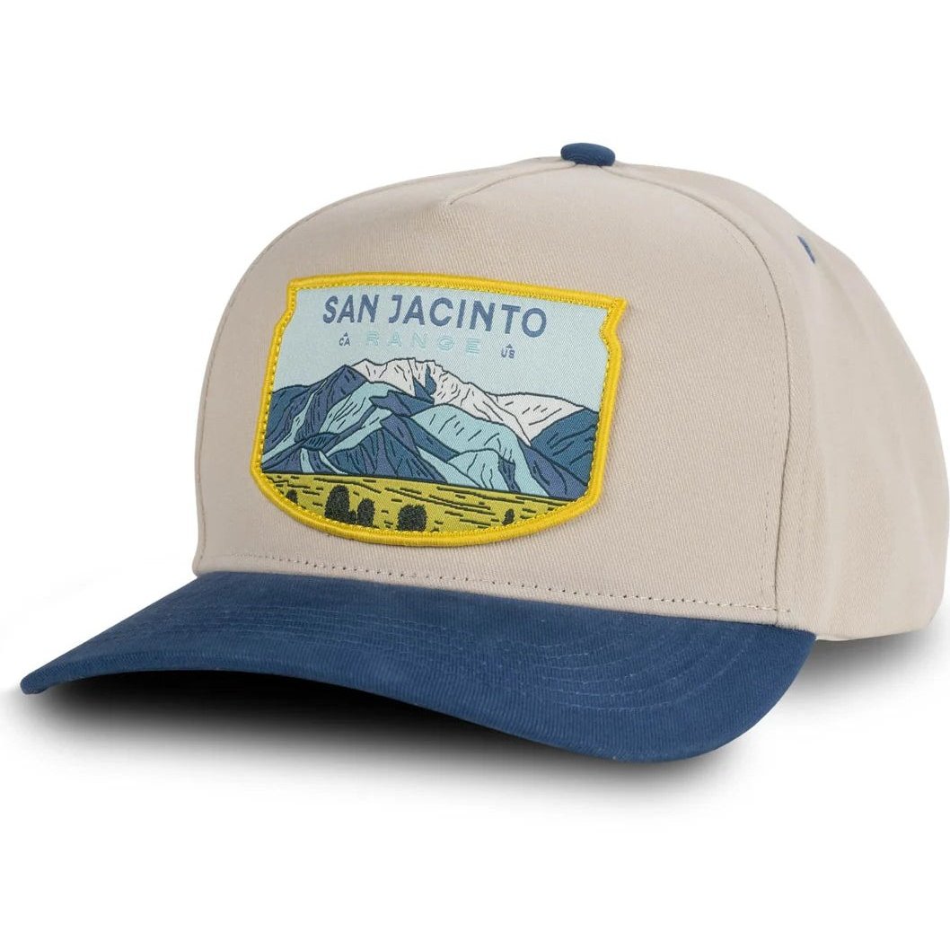 Angled view of the Sendero San Jacinto Range Hat - Sample in White/Blue showing the mountain patch on the front.