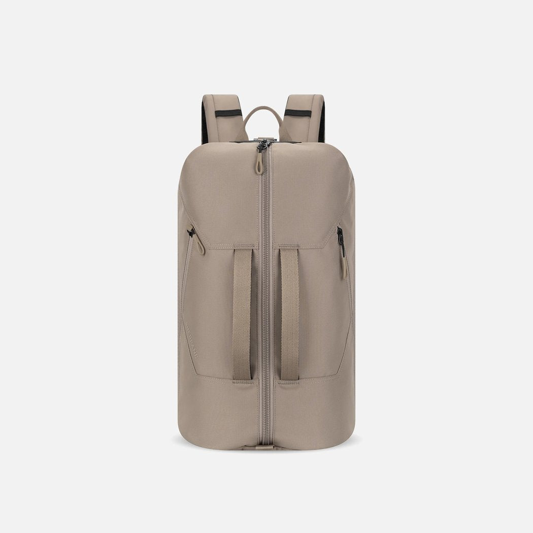 Front view of the Sherpani Juno | Travel Backpack in Dune Tan with a zippered top and two front pockets against a white background.