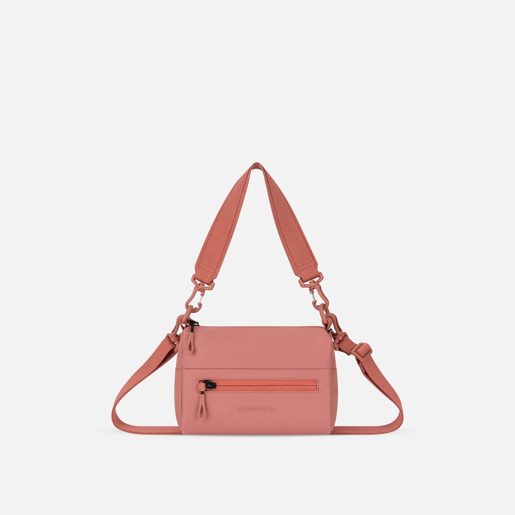 Front view of the Sherpani Skye Shoulder Bag in Desert Pink with a zippered pocket and adjustable strap against a white background.